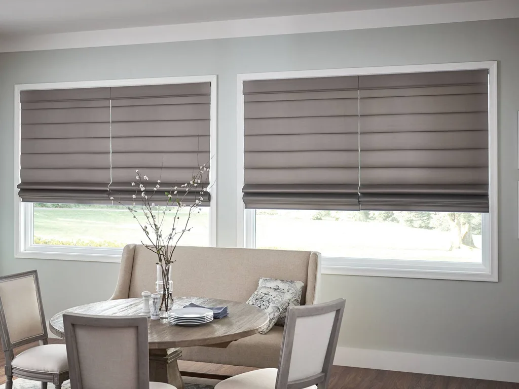 Elegant fabric Roman blinds neatly folded on a window in a Bengaluru home, adding warmth and a classic touch to the décor.