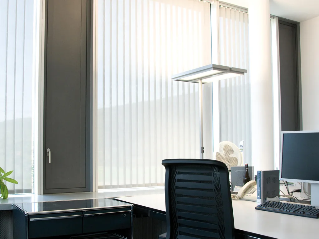 Modern vertical blinds neatly covering tall windows in a Bengaluru interior, offering adjustable light and privacy.
