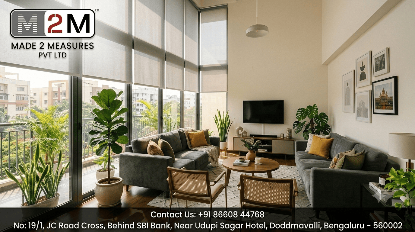 Sunlit modern apartment living room in Bangalore with large floor-to-ceiling windows and gray roller blinds.